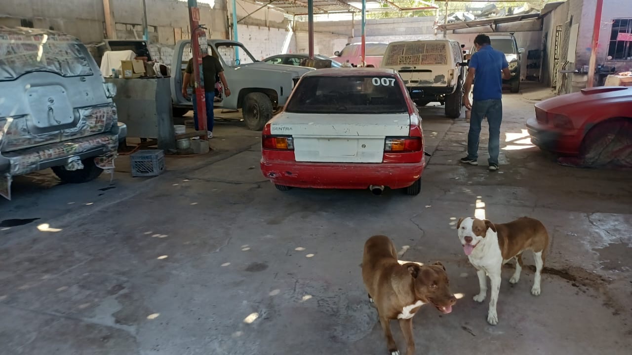 Interior del taller con vehículos en reparación